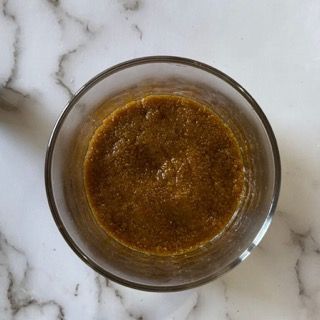 Un bicchiere pieno di liquido marrone su una superficie di marmo