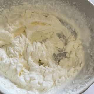 Una ciotola di panna montata con un cucchiaio dentro
