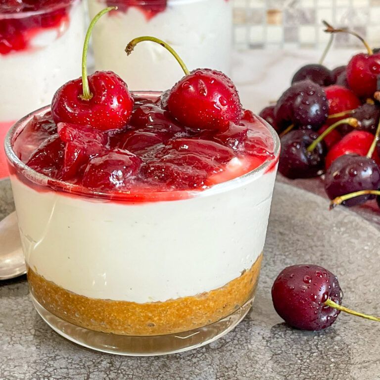 Un primo piano di un dessert con ciliegie sopra.