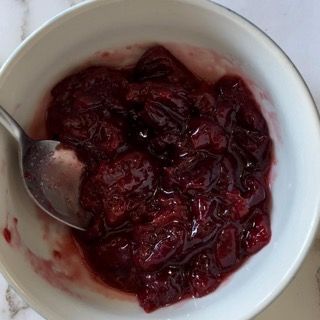 Una ciotola di salsa di mirtilli con un cucchiaio dentro