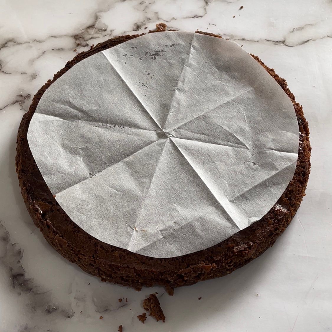 Una torta al cioccolato con un pezzo di carta oleata sopra