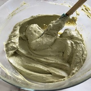 Una ciotola di glassa verde con una spatola dentro