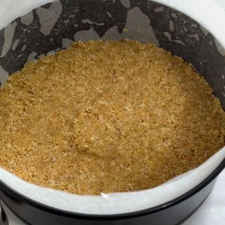 Una tortiera piena di biscotti Graham è appoggiata su un tavolo.