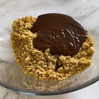 Una ciotola di vetro piena di briciole e salsa al cioccolato