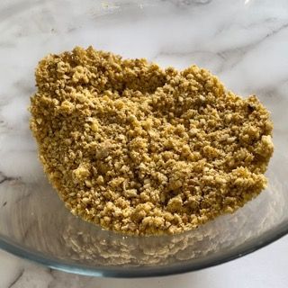 Una ciotola di vetro piena di briciole su un tavolo