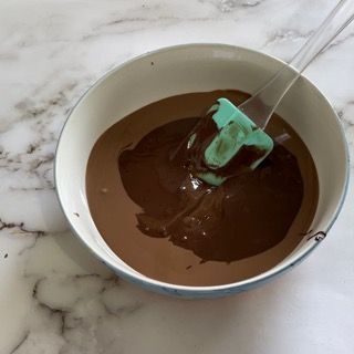 Una ciotola di salsa al cioccolato con una spatola dentro