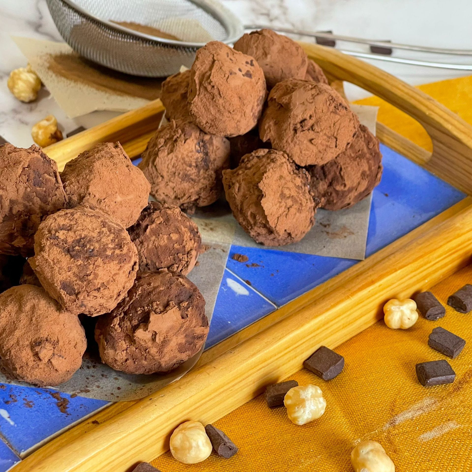 Un vassoio di legno pieno di tartufi al cioccolato e noci