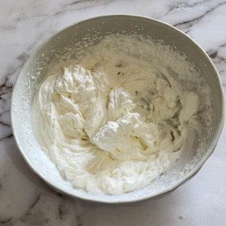 Una ciotola di panna montata è appoggiata su un tavolo.