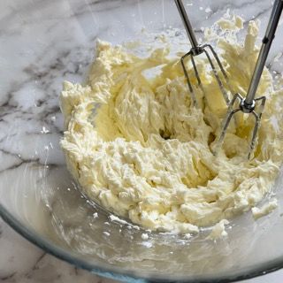 Una ciotola di panna montata con una frusta dentro.