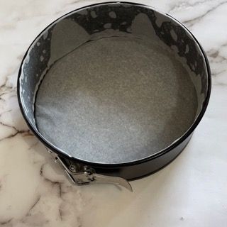 Una tortiera vuota è appoggiata su una superficie di marmo