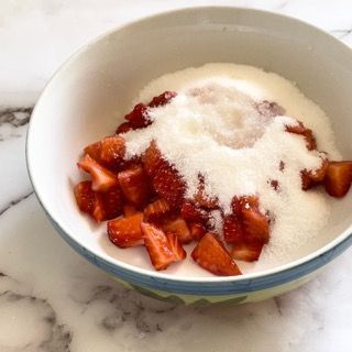 Una ciotola di fragole e zucchero su un tavolo