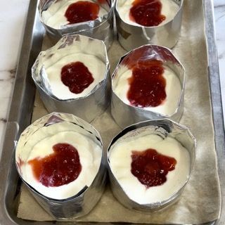 Un vassoio di vasetti di yogurt con sopra la marmellata di fragole