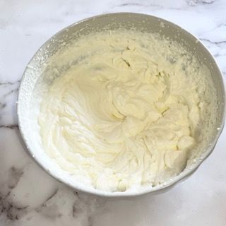 Una ciotola di panna montata è appoggiata su un tavolo.
