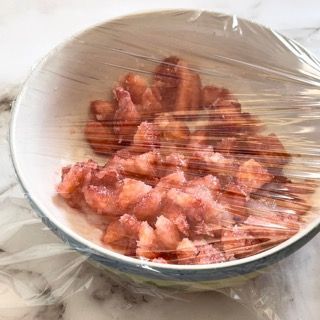 Una ciotola di cibo avvolta nella pellicola trasparente su un tavolo.
