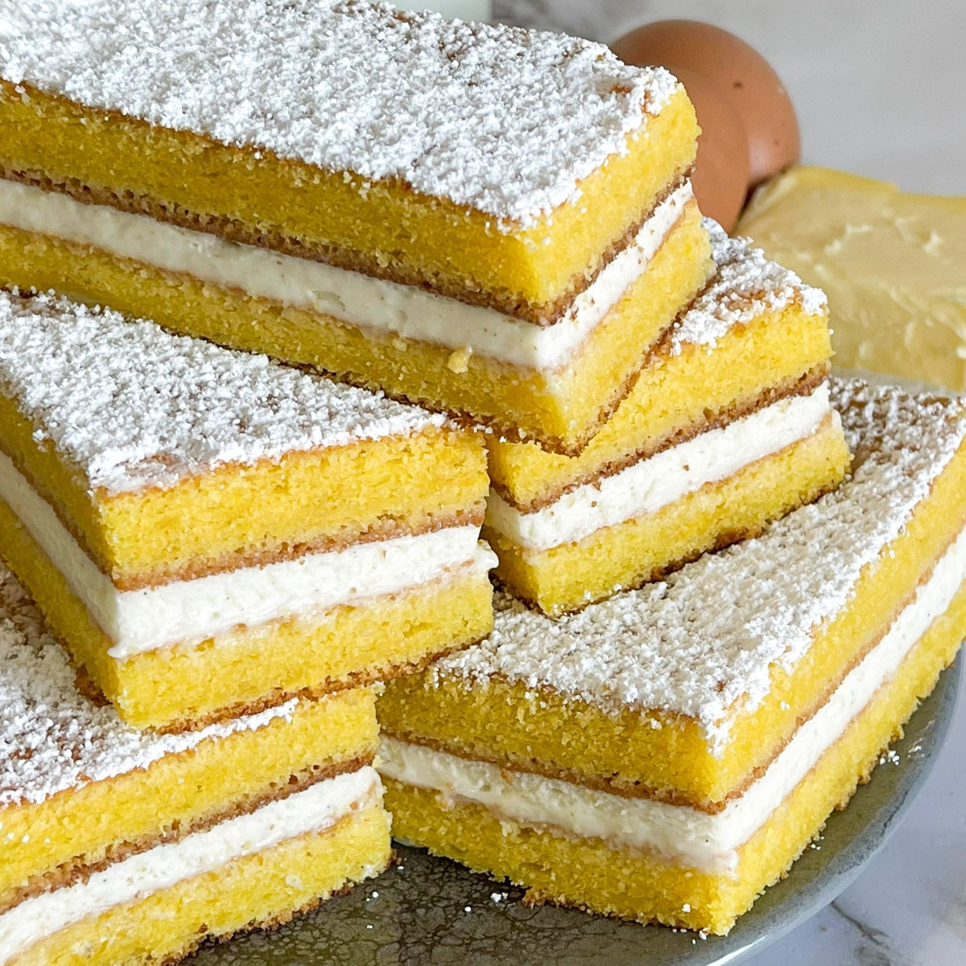 Una pila di fette di torta con zucchero a velo sopra
