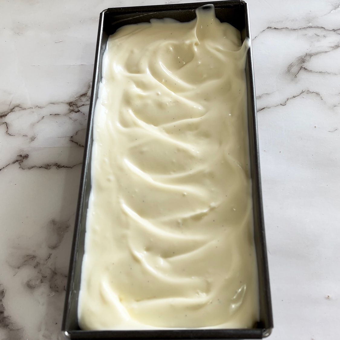 Una pagnotta di gelato in una padella su un tavolo.