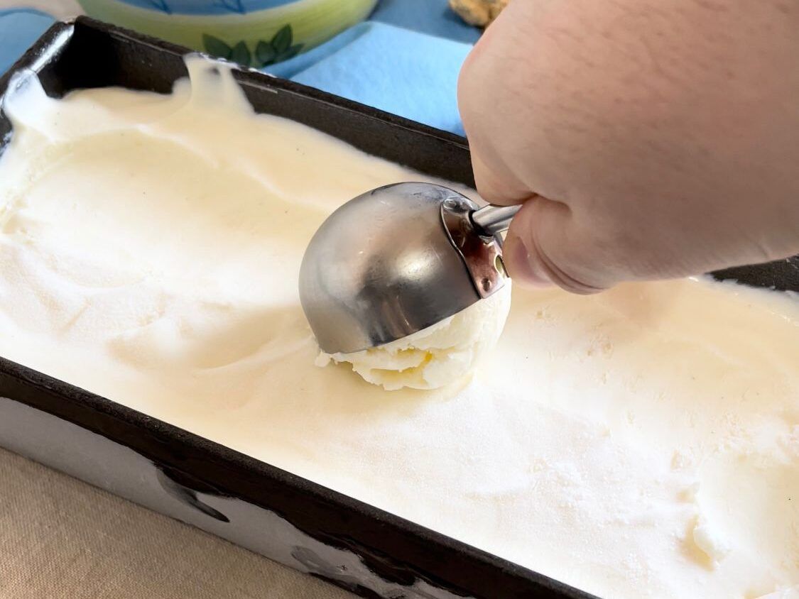 Una persona sta prendendo il gelato da un contenitore