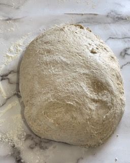 Una palla di pasta è appoggiata su una superficie di marmo.