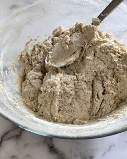 Una ciotola di impasto con un cucchiaio dentro su un tavolo.