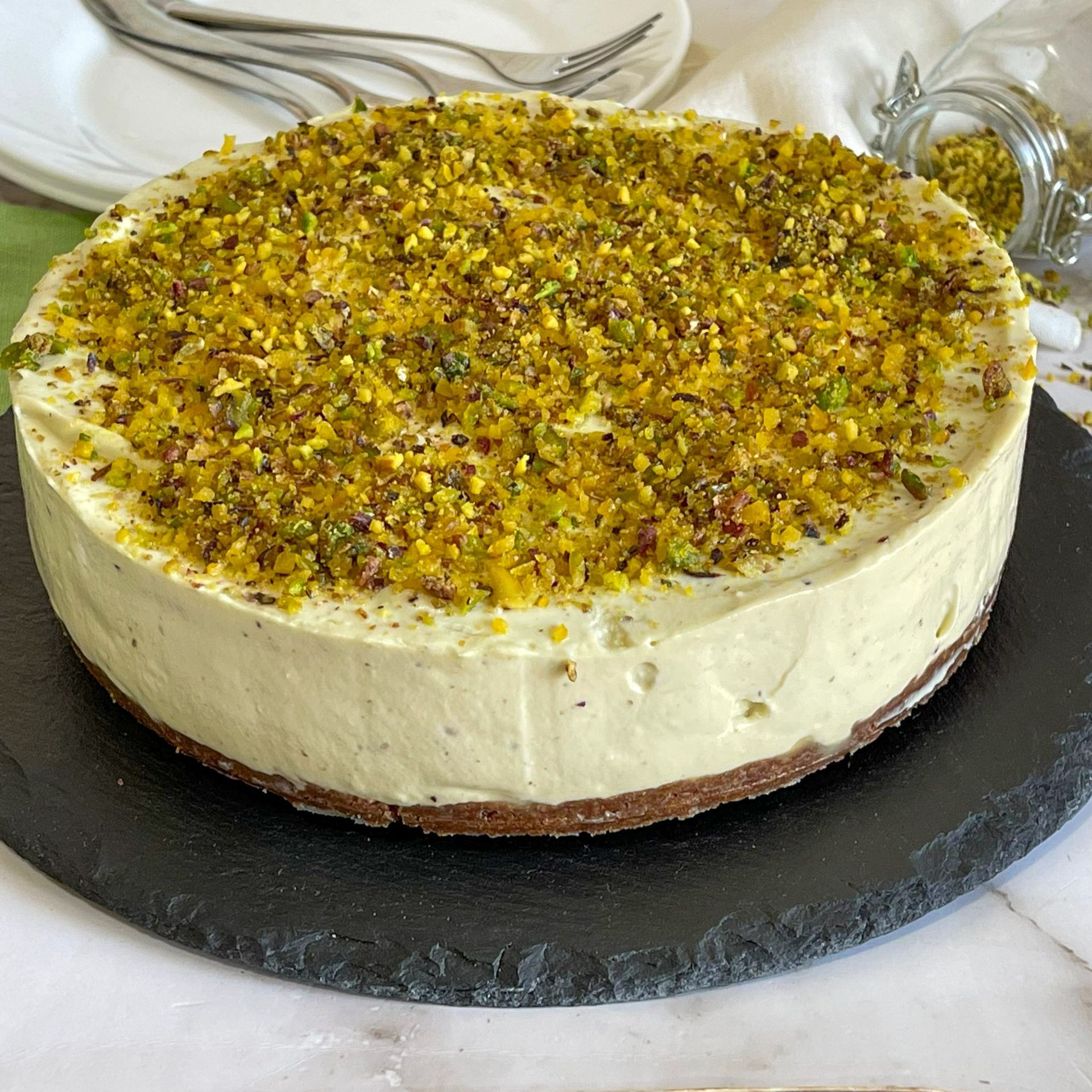 Una torta con pistacchi sopra è su un piatto nero