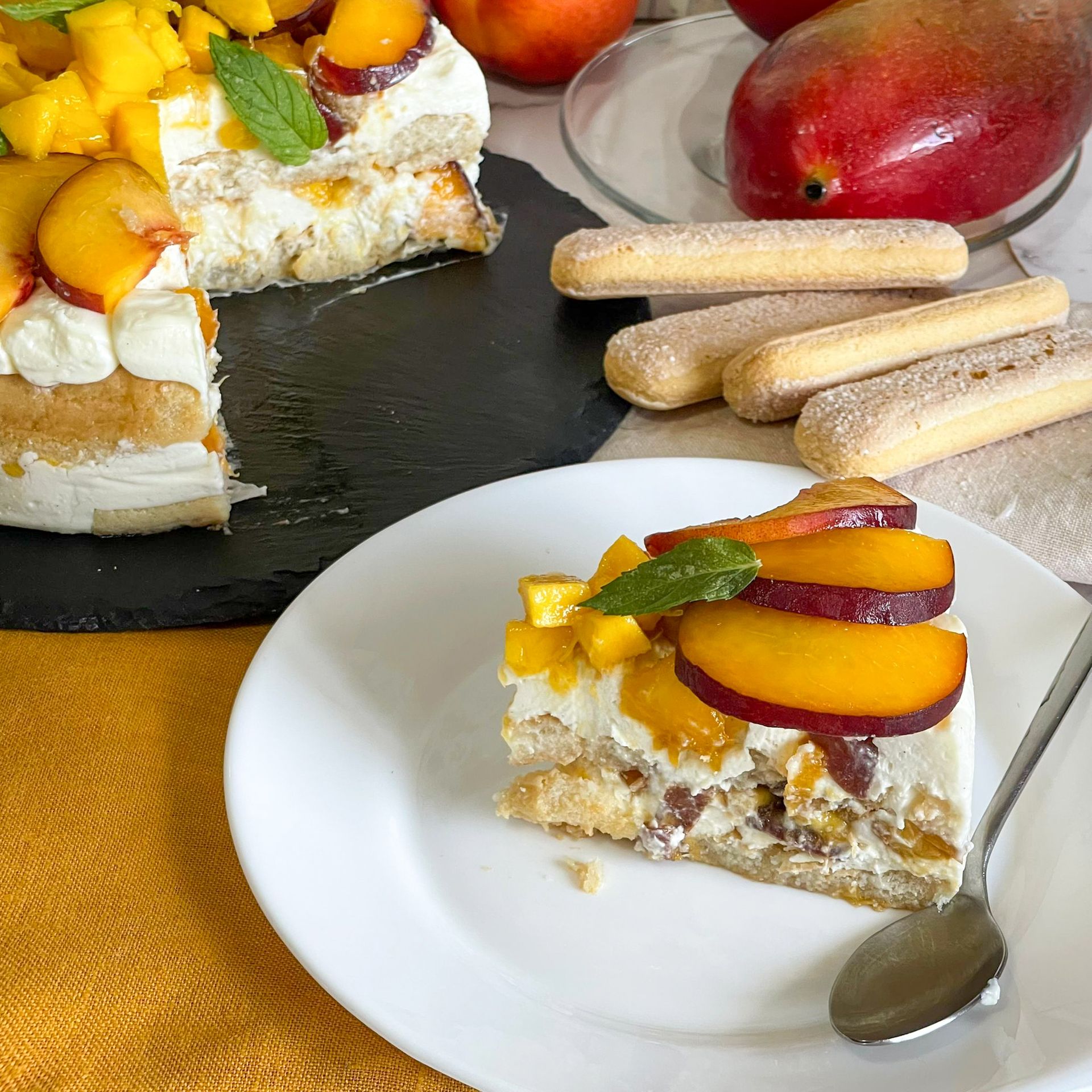 Un piatto bianco sormontato da una fetta di torta e un cucchiaio
