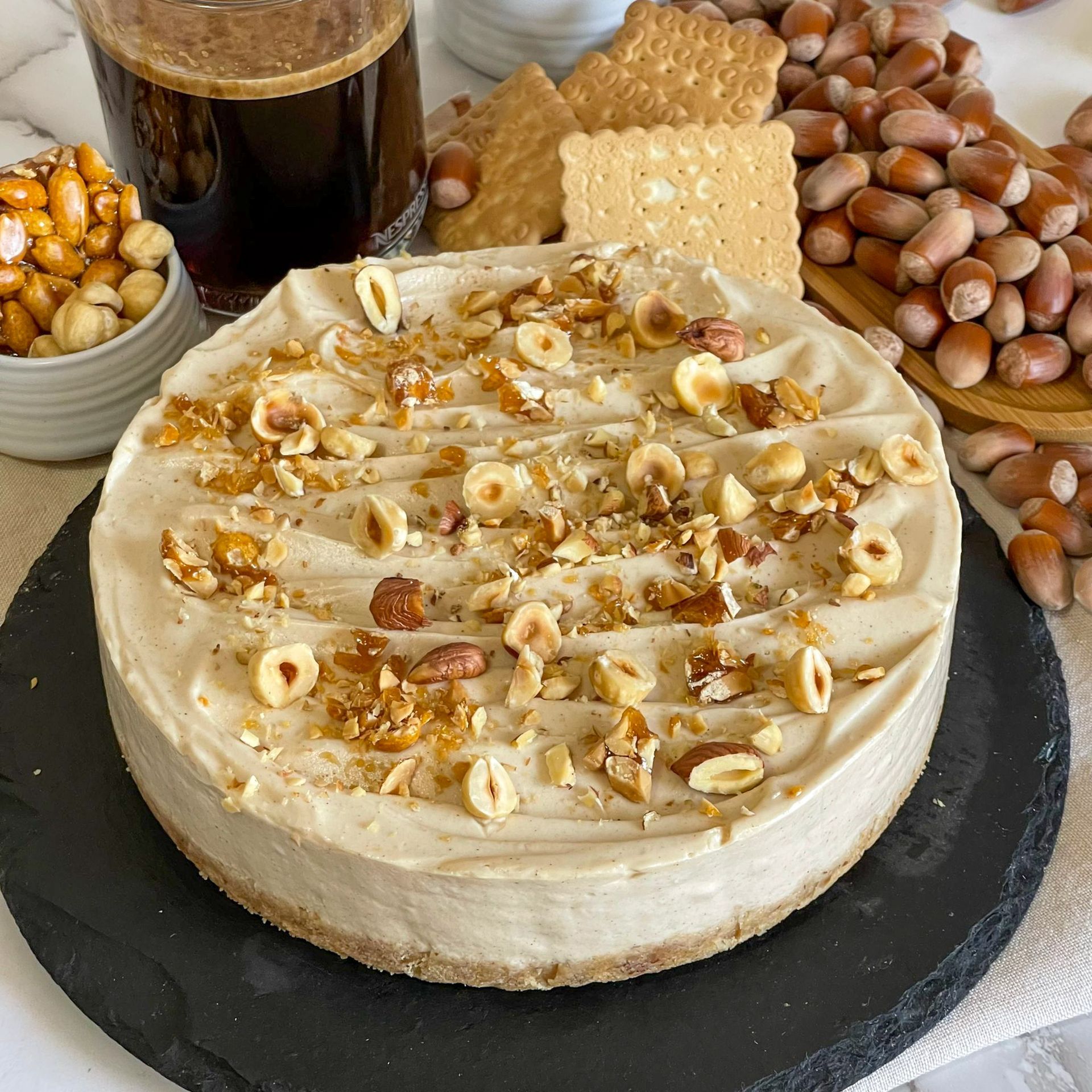 Una torta con sopra delle noci è appoggiata su un tavolo.