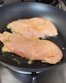 Due petti di pollo vengono cotti in una padella