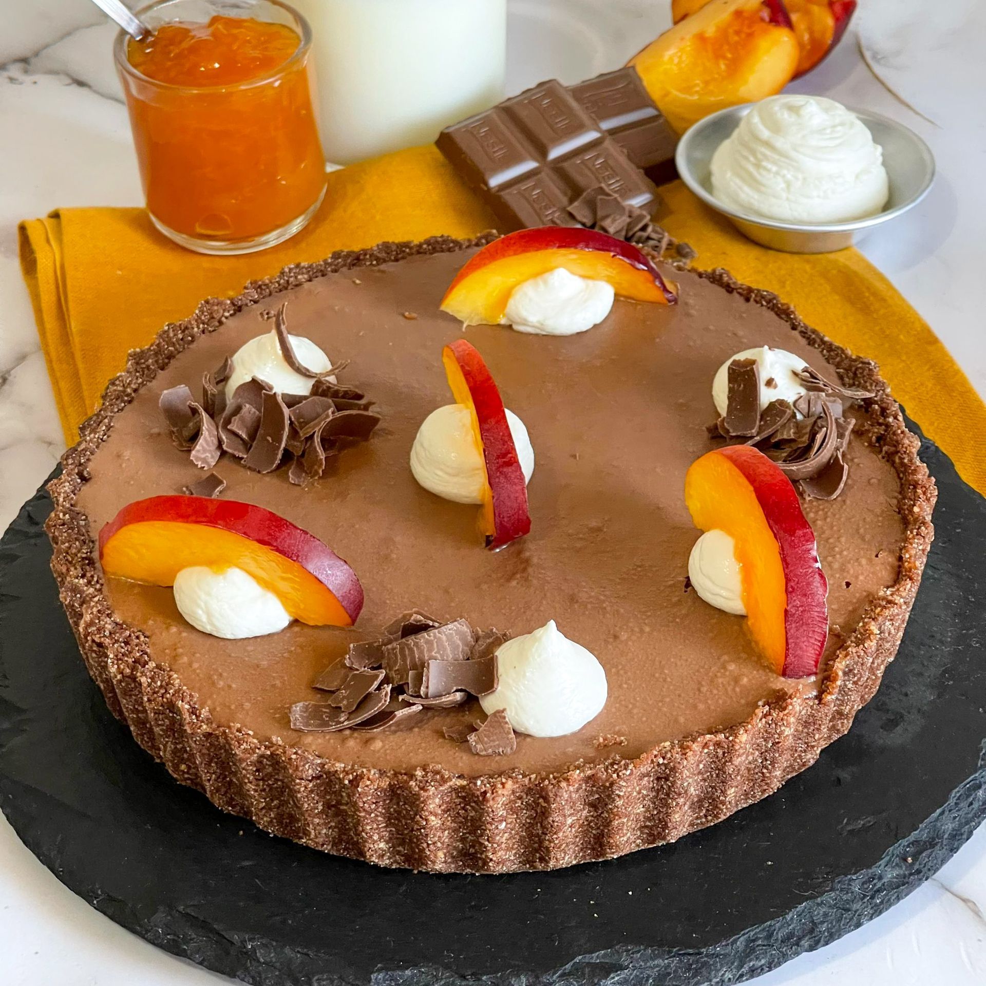 Una torta al cioccolato con pesche e panna montata sopra