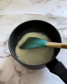 Una pentola di liquido con un cucchiaio dentro