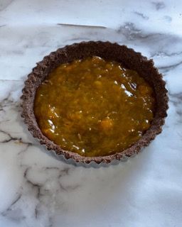 Una piccola ciotola di salsa gialla su una superficie di marmo