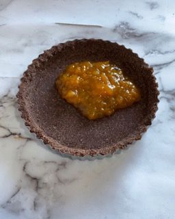 Una piccola ciotola di marmellata è appoggiata su un tavolo.