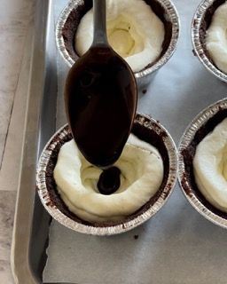 Un cucchiaio viene utilizzato per versare il cioccolato in un cupcake