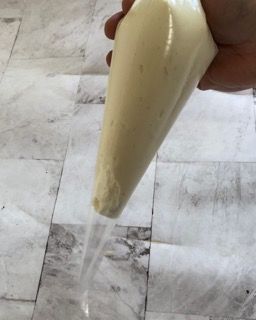 Una persona tiene in mano una sac à poche piena di glassa.