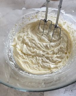 Una ciotola di panna montata con dentro un mixer