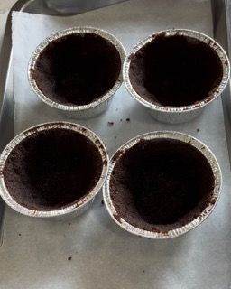 Quattro tazze di alluminio riempite di cioccolato su un vassoio