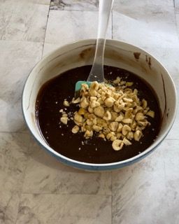 Una ciotola di salsa al cioccolato con arachidi e una spatola