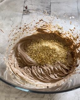 Una ciotola di glassa al cioccolato con noci dentro