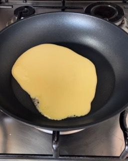 Un pancake viene cucinato in una padella sul fornello