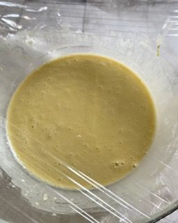 Una ciotola di zuppa è avvolta nella pellicola trasparente su un tavolo.