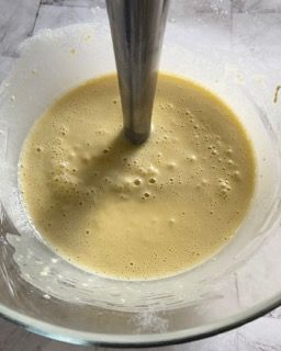 Primo piano di un frullatore in una ciotola piena di liquido.