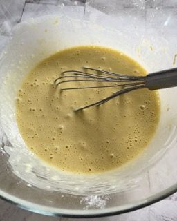 Una ciotola di pastella con una frusta dentro.