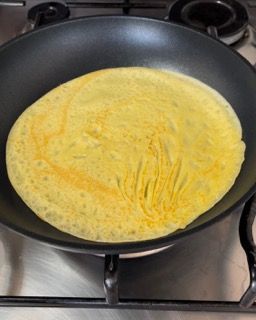 Un pancake sta cuocendo in una padella sul fornello