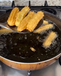 I churros vengono cucinati in una padella sul fornello