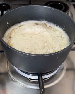Una pentola di cibo sta cuocendo sul fornello.
