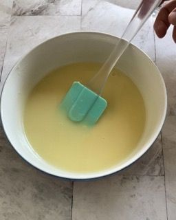 Una persona sta mescolando qualcosa in una ciotola con una spatola.