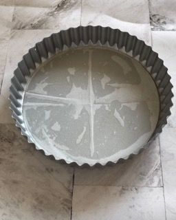 Una teglia per torta è appoggiata su un pavimento piastrellato
