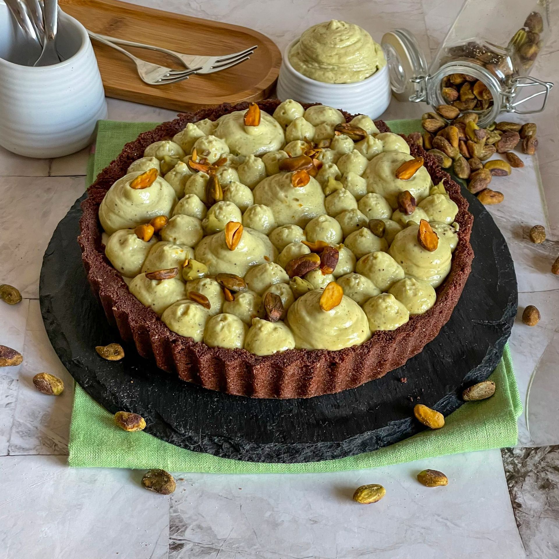 Una torta con pistacchi sopra è appoggiata su un tavolo.