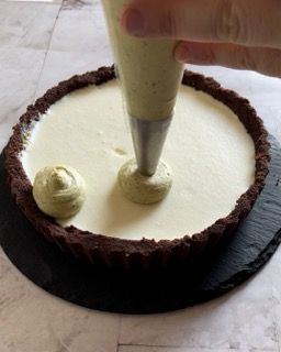 Una persona sta glassando una torta con una sac à poche