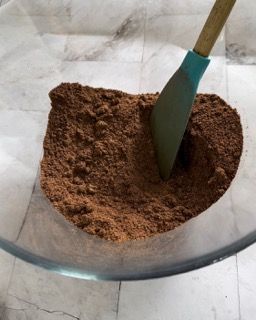 Una ciotola di cacao in polvere con una spatola dentro