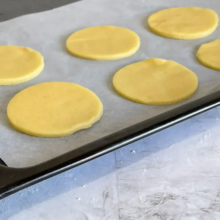 Pasta frolla stesa con un mattarello su un piano di lavoro infarinato, pronta per essere usata per una crostata